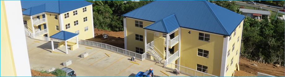 An aerial view of two yellow apartment buildings with blue roofs built by Bluewater Construction